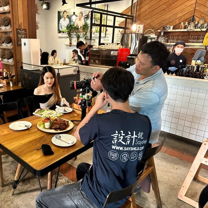 Creator filming a plated main at a busy Chiang Mai brunch café