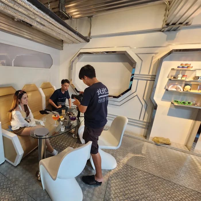 Guests seated in the capsule-pod booths of a futuristic Chiang Mai café
