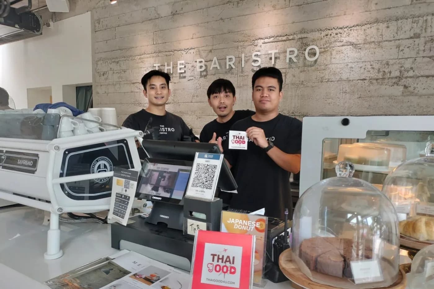 Café staff at a Wegood4u partner venue holding the partner cards by the till